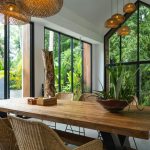 A dining room with a large wooden table surrounded by chairs