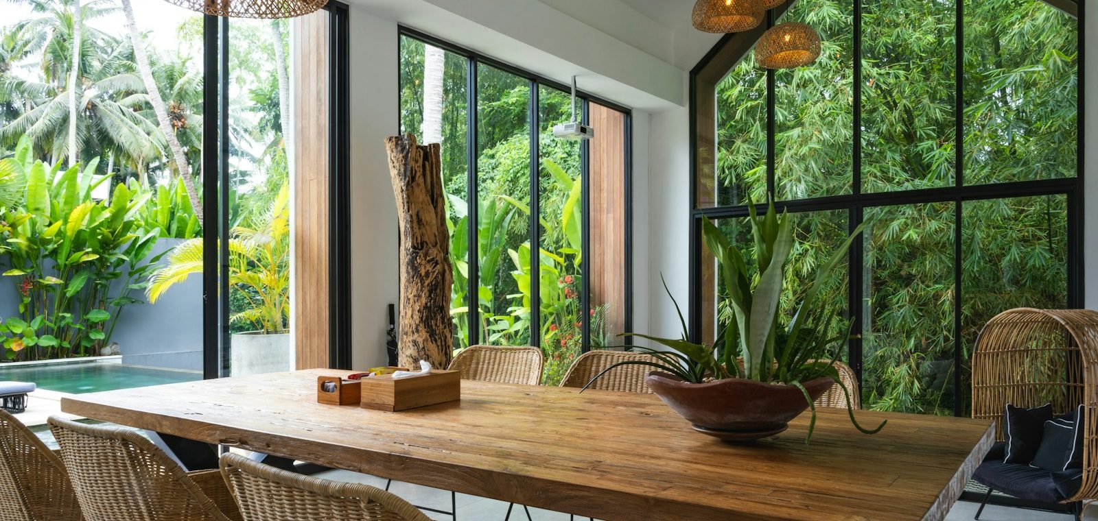 A dining room with a large wooden table surrounded by chairs