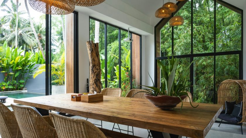 A dining room with a large wooden table surrounded by chairs