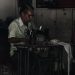 man sitting on chair working on sewing machine