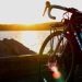 black bicycle near body of water during sunset